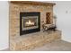 Close-up of cozy brick fireplace with gas logs and wood storage at 12319 W Burgundy Ave, Littleton, CO 80127