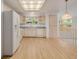 Spacious kitchen features natural wood floors, and white appliances at 12319 W Burgundy Ave, Littleton, CO 80127