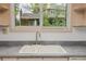 Double kitchen sink and faucet with view of backyard trees and house out the window at 12319 W Burgundy Ave, Littleton, CO 80127