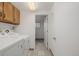 Bright laundry room featuring tiled floors, washer and dryer, and wooden cabinets for convenient storage at 12319 W Burgundy Ave, Littleton, CO 80127