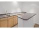 Finished basement wet bar with wooden cabinets and gray countertop at 12319 W Burgundy Ave, Littleton, CO 80127