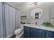Bathroom featuring a toilet, shower with gray curtain, vanity, and decorative elements at 10523 Ashfield St # 5C, Highlands Ranch, CO 80126