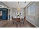 Chic dining room features a modern chandelier and table, with natural light from a large window at 10523 Ashfield St # 5C, Highlands Ranch, CO 80126