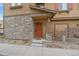 Charming townhouse exterior with a stone facade, a welcoming front door, and manicured landscaping at 10523 Ashfield St # 5C, Highlands Ranch, CO 80126