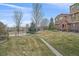 Exterior view of the property showcasing the lawn, mature trees, and a well-maintained landscape at 10523 Ashfield St # 5C, Highlands Ranch, CO 80126