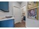 Hallway featuring blue cabinets, marble countertop, and bathroom access at 10523 Ashfield St # 5C, Highlands Ranch, CO 80126