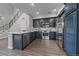 Well-lit kitchen boasts navy cabinets, stainless steel appliances, and an island, complemented by modern wood flooring at 10523 Ashfield St # 5C, Highlands Ranch, CO 80126