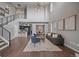 Open-concept living room features high ceilings, modern chandelier, wood floors, and seamless flow to kitchen and dining area at 10523 Ashfield St # 5C, Highlands Ranch, CO 80126