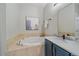 Bathroom showing soaking tub and adjacent vanity with marble countertop at 10523 Ashfield St # 5C, Highlands Ranch, CO 80126