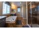 Modern bathroom featuring a soaking tub, elegant fixtures, and a glass-enclosed shower at 24661 E Layton Pl, Aurora, CO 80016