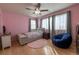 Stylish pink bedroom featuring natural light, hardwood floors, and comfortable furniture, ideal for relaxation and rest at 24661 E Layton Pl, Aurora, CO 80016