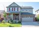 Charming two-story home with a brick and siding exterior, covered porch, and attached two-car garage at 24661 E Layton Pl, Aurora, CO 80016