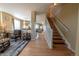 Open hallway with hardwood floors, staircase with white railing, and views into the adjacent living spaces at 24661 E Layton Pl, Aurora, CO 80016