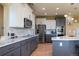 Modern kitchen with white cabinets, stainless steel appliances, marble countertops and hardwood floors at 24661 E Layton Pl, Aurora, CO 80016