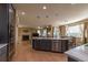 Spacious kitchen and dining area featuring an island, wood floors, and a fireplace in the adjacent living room at 24661 E Layton Pl, Aurora, CO 80016