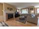Cozy living room with fireplace, hardwood floors, comfortable seating, and large windows for natural light at 24661 E Layton Pl, Aurora, CO 80016