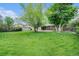 Spacious backyard featuring a large lawn, mature trees and a storage shed at 6427 S Ingalls St, Littleton, CO 80123