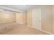 Finished basement with neutral carpet, a window and a white door at 6427 S Ingalls St, Littleton, CO 80123