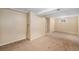 Neutral colored finished basement area with neutral carpet at 6427 S Ingalls St, Littleton, CO 80123
