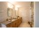 Modern bathroom featuring double sinks, wood cabinets, quartz countertops, a glass shower, and elegant fixtures at 3600 N Pecos St, Denver, CO 80211