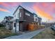 Modern home featuring wood and stucco siding, with a privacy fence and beautiful sunset in the background at 3600 N Pecos St, Denver, CO 80211