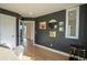 Home office featuring hardwood floors, dark accent walls, decorative wall art, and a modern bar cart at 3600 N Pecos St, Denver, CO 80211