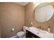 Stylish powder room features a unique wallpaper and a gold-framed round mirror at 3600 N Pecos St, Denver, CO 80211