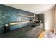 Contemporary wet bar design with stylish backsplash, wood shelves, and sleek gray cabinetry at 3600 N Pecos St, Denver, CO 80211