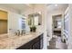 View of the bathroom with granite countertop, cabinet, and dual mirrors at 6063 Eldora St, Golden, CO 80403