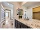 View of the bathroom with granite countertop, cabinet, and dual mirrors at 6063 Eldora St, Golden, CO 80403