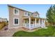 Back exterior view of two-story house with covered patio and well-maintained yard at 6063 Eldora St, Golden, CO 80403