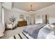 Bright primary bedroom showcasing a plush bed, modern chandelier, and comfortable sitting area at 6063 Eldora St, Golden, CO 80403