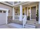 Inviting front porch with white columns, stone accents, and a freshly painted front door at 6063 Eldora St, Golden, CO 80403