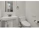 Small bathroom features a white pedestal sink, bronze fixtures, and toilet with an elongated bidet seat at 9353 Middle Fork St, Littleton, CO 80125