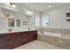 Primary bathroom featuring a soaking tub, tiled shower, dual sink vanity, and modern lighting at 9353 Middle Fork St, Littleton, CO 80125
