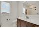 Bathroom featuring a wood vanity, mirror, window and toilet at 9353 Middle Fork St, Littleton, CO 80125