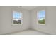 Neutral bedroom featuring two windows providing natural light and scenic views at 9353 Middle Fork St, Littleton, CO 80125