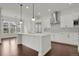 Bright kitchen featuring white cabinetry, an island with seating, and modern stainless steel appliances at 9353 Middle Fork St, Littleton, CO 80125