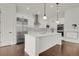 Bright kitchen featuring white cabinetry, an island with seating, and modern stainless steel appliances at 9353 Middle Fork St, Littleton, CO 80125