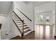 Beautiful staircase with dark wood steps and white railings leading to a sun-filled living area at 9353 Middle Fork St, Littleton, CO 80125
