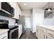 Modern kitchen with white cabinets, stainless steel appliances and view into laundry room at 7924 Florado St, Denver, CO 80221