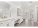 Primary bathroom featuring double sink vanity, framed mirrors, tile floors, and ensuite access to main bedroom at 5226 Inland Ave, Firestone, CO 80504