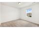 Well-lit bedroom featuring a window with neighborhood views and plush carpeting at 5226 Inland Ave, Firestone, CO 80504