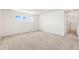 Spacious bedroom with plush carpet, three windows providing natural light, and ensuite bathroom access at 5226 Inland Ave, Firestone, CO 80504