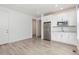 Well-lit kitchen featuring stainless steel appliances, white cabinets, and hardwood floors at 5226 Inland Ave, Firestone, CO 80504