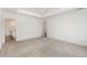 Large primary bedroom with neutral carpet, tray ceiling, recessed lighting, and ensuite bathroom entrance at 5226 Inland Ave, Firestone, CO 80504