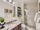 Beautiful bathroom with a glass-enclosed shower, granite countertops, and stylish black shelving at 11275 Holly St, Thornton, CO 80233