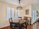 Dining room with a wooden table, bench seating, shuttered windows, and modern chandelier at 11275 Holly St, Thornton, CO 80233