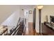 Second story landing with wood floors and metal banister, featuring a decorative mirror and statement lamp at 11275 Holly St, Thornton, CO 80233