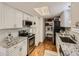 Bright kitchen featuring white cabinetry, granite countertops, and stainless steel appliances at 11275 Holly St, Thornton, CO 80233